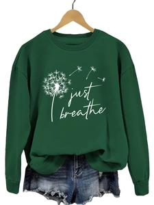 Détail de l'imprimé pissenlit Just Breathe sur sweat vert foncé et short en denim