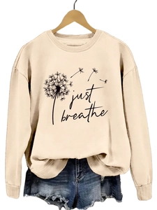 Détail de l'imprimé pissenlit Just Breathe sur sweat beige et short en jean vieilli