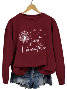 Détail du sweat-shirt bordeaux avec texte Just Breathe et imprimé de pissenlit