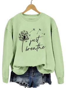 Détail de l'imprimé pissenlit sur le sweat-shirt à manches longues vert clair à col rond