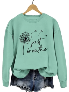 Détail du sweat vert menthe Just Breathe avec imprimé pissenlit et short en jean