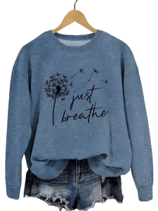 Détail de l'imprimé pissenlit Just Breathe sur le tissu du sweat à col rond gris-bleu