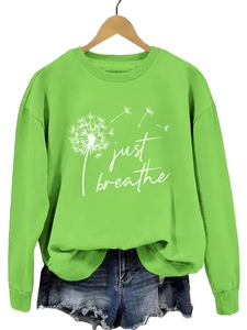 Détail du sweat à manches longues vert avec texte Just Breathe et motif pissenlit