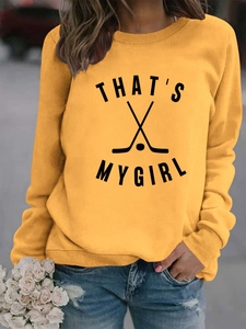 Détail des poignets côtelés et de l'imprimé That's My Girl sur le sweat-shirt moutarde