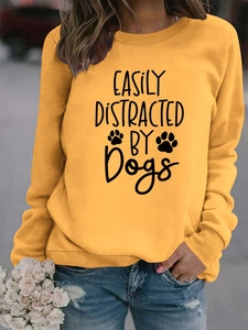 Detail of Mustard Yellow sweatshirt featuring Easily Distracted by Dogs print with jeans