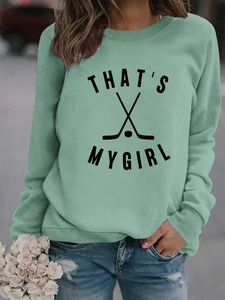 Détail du sweat vert sauge avec crosses de hockey et impression texte THAT'S MY GIRL