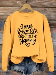 Détail du sweat-shirt orange avec le slogan imprimé 'my FAVORITE PEOPLE CALL ME Nanny'