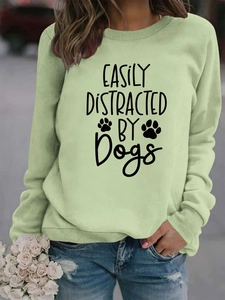 Close-up of light green sweatshirt featuring black Dogs slogan print and ribbed cuffs