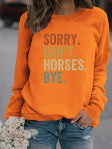 Détail de l'imprimé SORRY CAN'T HORSES sur un sweat-shirt orange col rond pour femme