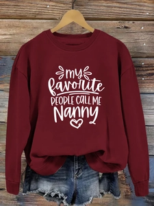 Détail du sweat bordeaux à col rond avec motif 'My Favorite People' sur fond de bois