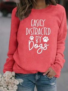 Close-up of Easily Distracted by Dogs slogan and paw prints on red pullover sweatshirt