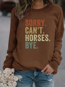 Détail des poignets côtelés et du slogan SORRY. CAN'T. HORSES. BYE. sur le sweat marron