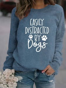 Close-up of 'Easily Distracted by Dogs' print on a blue-grey crewneck sweatshirt