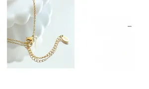 Gros plan du fermoir plaqué or 18 carats et du poinçon K18 sur le collier boussole