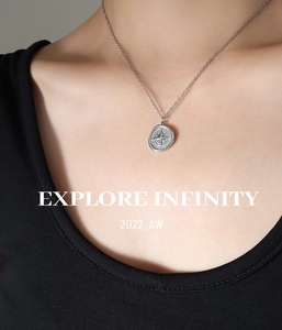 Gros plan du collier pendentif boussole en argent avec motif d'étoile gravé sur le cou