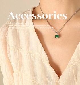 Close-up of emerald-cut green zircon pendant necklace on silver snake chain with model