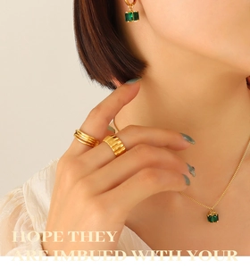 Detailed view of emerald zircon jewelry set with gold necklace and matching earrings