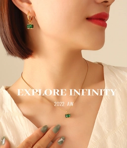 Close-up of gold emerald jewelry set with square zircon necklace and earrings on model