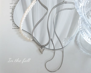 Détail d'un collier multicouche avec perles d'eau douce et pendentif cœur en argent