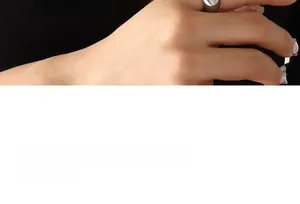 Gros plan d'une bague minimaliste en acier inoxydable argenté portée à l'index, vue duo