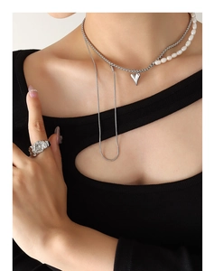 Détail d'un collier multicouche en perles d'eau douce avec pendentif cœur sur un modèle