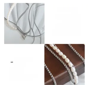 Détail de perles d'eau douce et pendentif coeur poli sur un collier en acier titane