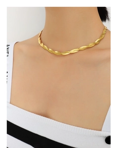 Close-up of twisted double-layer gold snake chain necklace on model's neckline