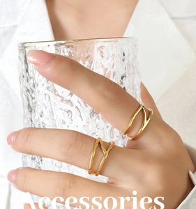 Detail of 18K gold-plated double-layer geometric wave ring on hand with glass