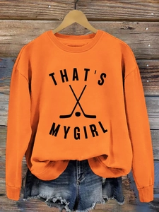 Détail du sweat orange avec imprimé hockey That's My Girl et poignets côtelés