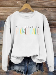 Close-up of pickleball slogan print on white crewneck sweatshirt with wooden background