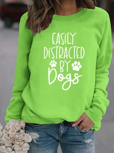 Detail of lime green pullover sweatshirt with white Easily Distracted by Dogs print