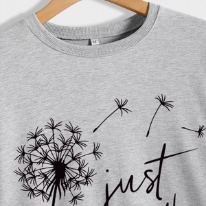 Sweat gris Just Breathe avec imprimé pissenlit sur un cintre en bois