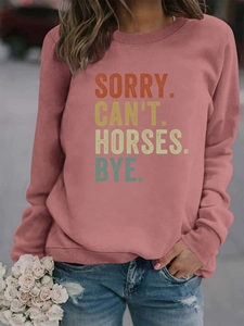 Détail du sweat à col rond avec imprimé Sorry Can't Horses Bye sur tissu brique