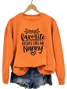 Détail d'un sweat orange avec inscription noire my favorite people nanny et col rond