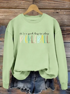 Detail of light green sweatshirt featuring it's a good day to play pickleball print