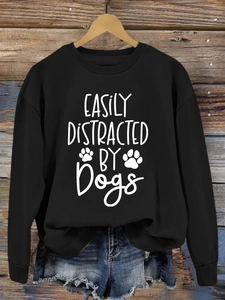 Close-up of the easily distracted by dogs print on a black long sleeve sweatshirt