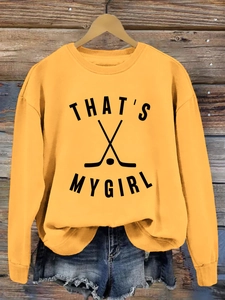Détail du sweat-shirt jaune avec motif de hockey et inscription That's My Girl