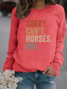 Détail macro du sweat rouge avec texte Sorry Can't Horses Bye et roses blanches