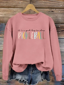 Pink pickleball sweatshirt detail with 'it's a good day to play' print and denim shorts