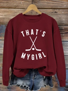 Détail du sweat bordeaux avec graphisme hockey THAT'S MY GIRL sur fond de bois