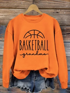 Detail of orange sweatshirt with BASKETBALL grandma print and ribbed sleeve cuffs