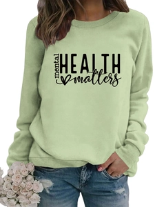Detail of light green sweatshirt with Mental Health Matters print and soft fabric texture