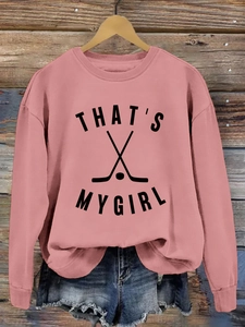 Sweat rose col rond imprimé That's My Girl avec un short en jean sur fond bois