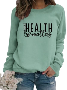 Close-up of Mental Health Matters lettering and heart design on mint green sweatshirt