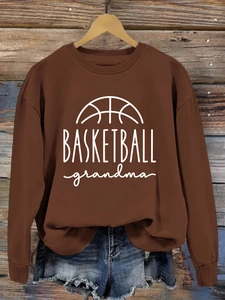 Close-up of Basketball Grandma print on a brown crewneck sweatshirt hung on a hanger