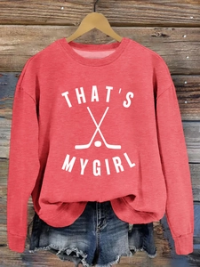 Détail d'un sweat rouge à col rond avec motif That's My Girl et logo de hockey