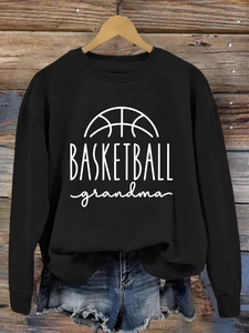 Close-up of Basketball Grandma print on a black cotton crewneck sweatshirt with denim shorts
