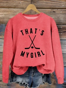 Détail du sweat corail avec motif de hockey THAT'S MY GIRL sur fond de bois vintage