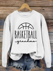 Close-up of Basketball Grandma slogan print on white crewneck sweatshirt with wooden hanger