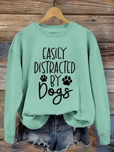 Close-up of mint green crewneck sweatshirt with easily distracted by dogs print